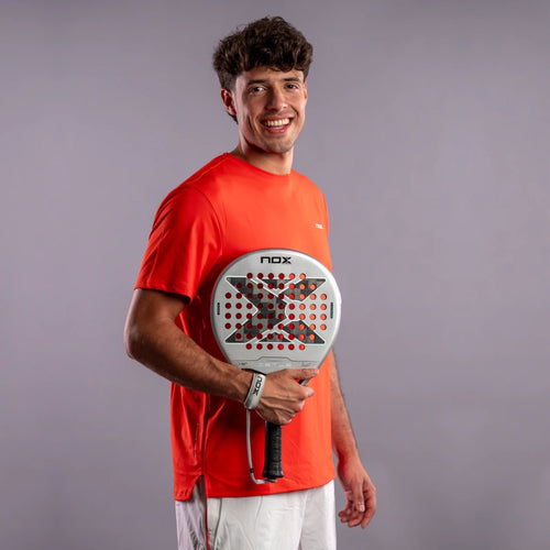 Raquette de padel NOX Genius 12K Alum XTREM 2027 by Agustín Tapia, un joueur tenant la raquette, portrait en studio
