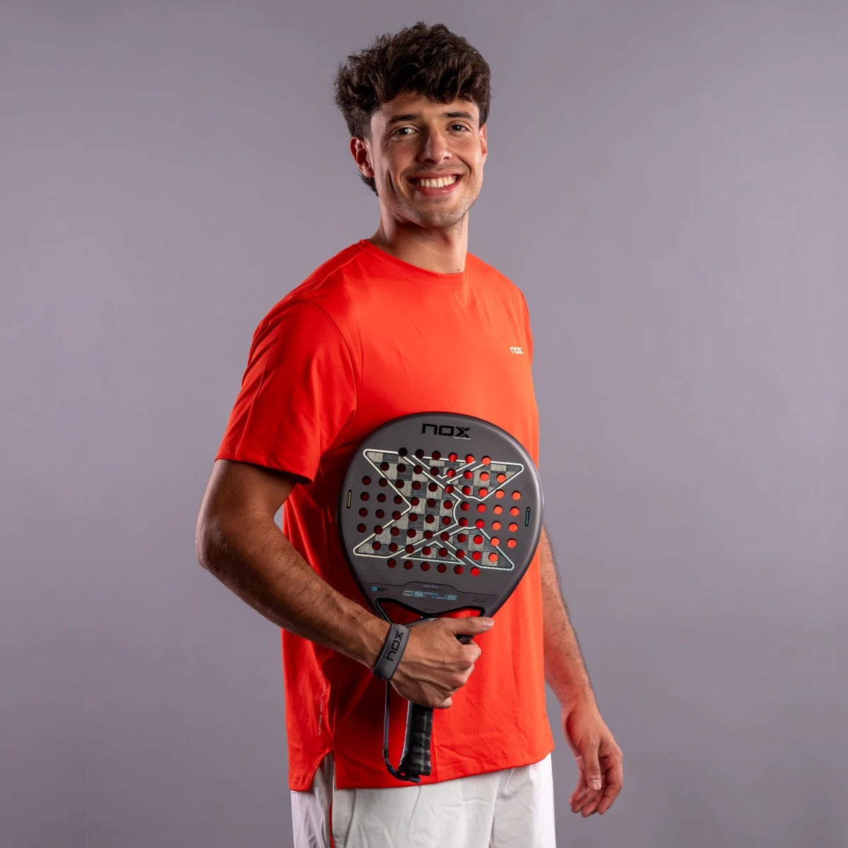 Raquette de padel NOX Genius 18K Alum 2027 by Agustín Tapia, un joueur tenant la raquette, portrait en studio