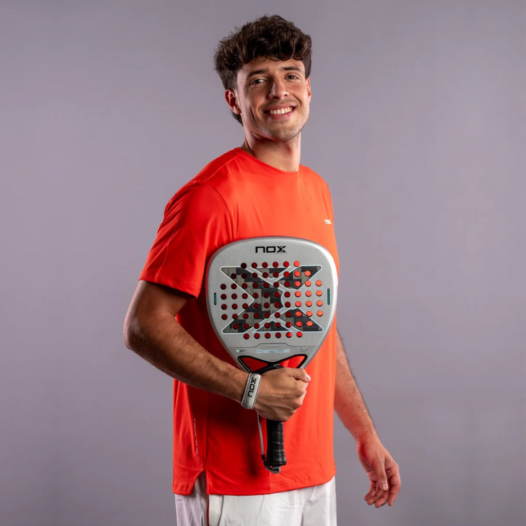 Raquette de padel NOX Genius Attack 12K Alum XTREM 2027 by Agustín Tapia, un joueur tenant la raquette, portrait en studio