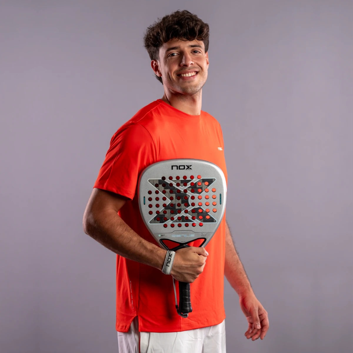Raquette de padel NOX Genius Attack 12K Alum XTREM 2027 by Agustín Tapia, un joueur tenant la raquette, portrait en studio